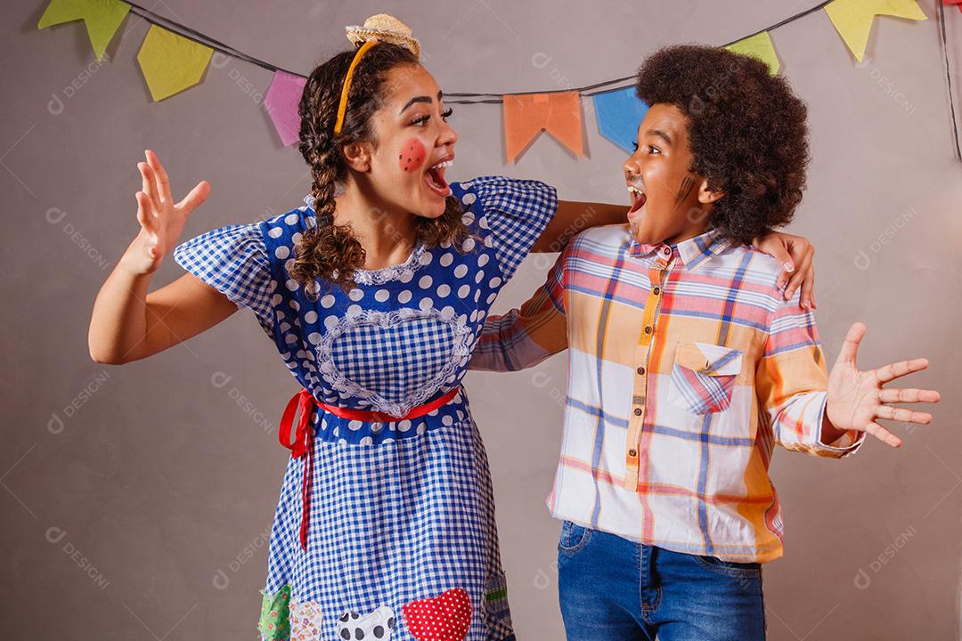 Mulher adulta e crianças vestidas para festa junina