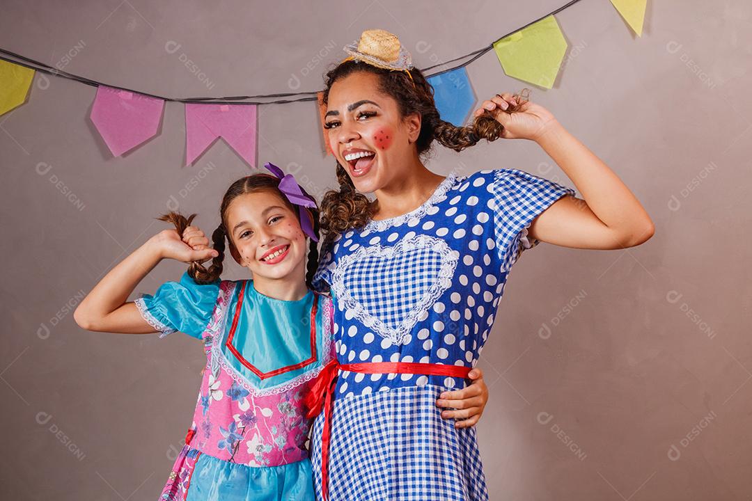 Mulher adulta e crianças vestidas para festa junina