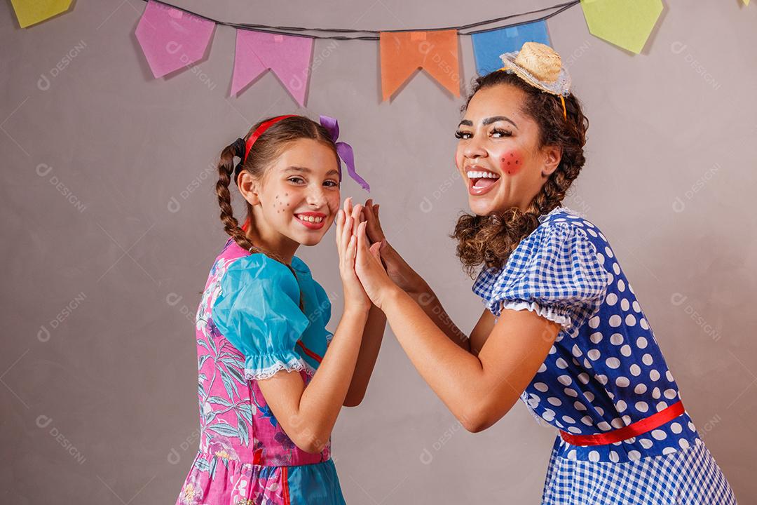 Mulher adulta e crianças vestidas para festa junina