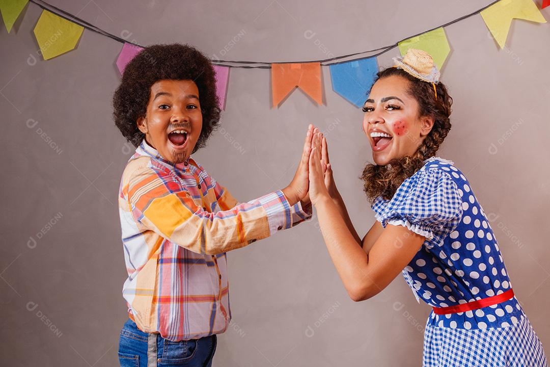 Mulher adulta e crianças vestidas para festa junina