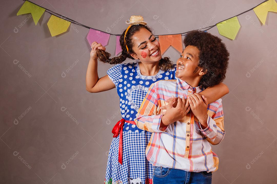 Mulher adulta e crianças vestidas para festa junina