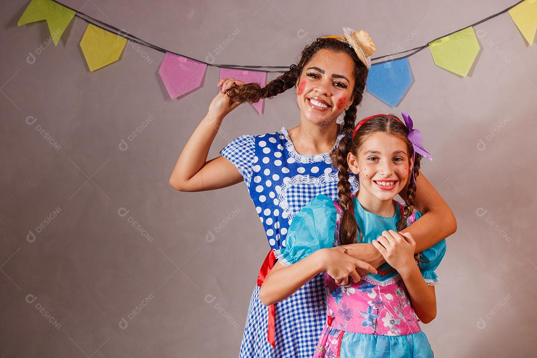 Mulher adulta e crianças vestidas para festa junina