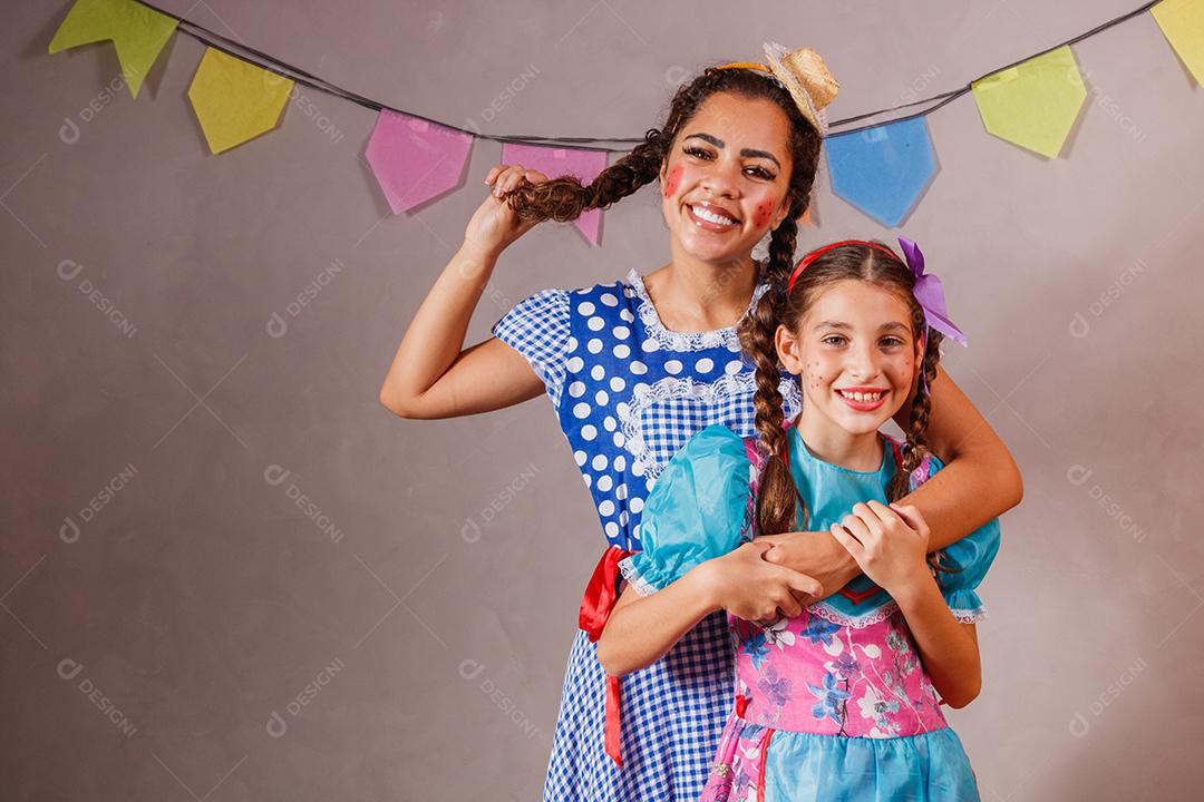 Mulher adulta e crianças vestidas para festa junina