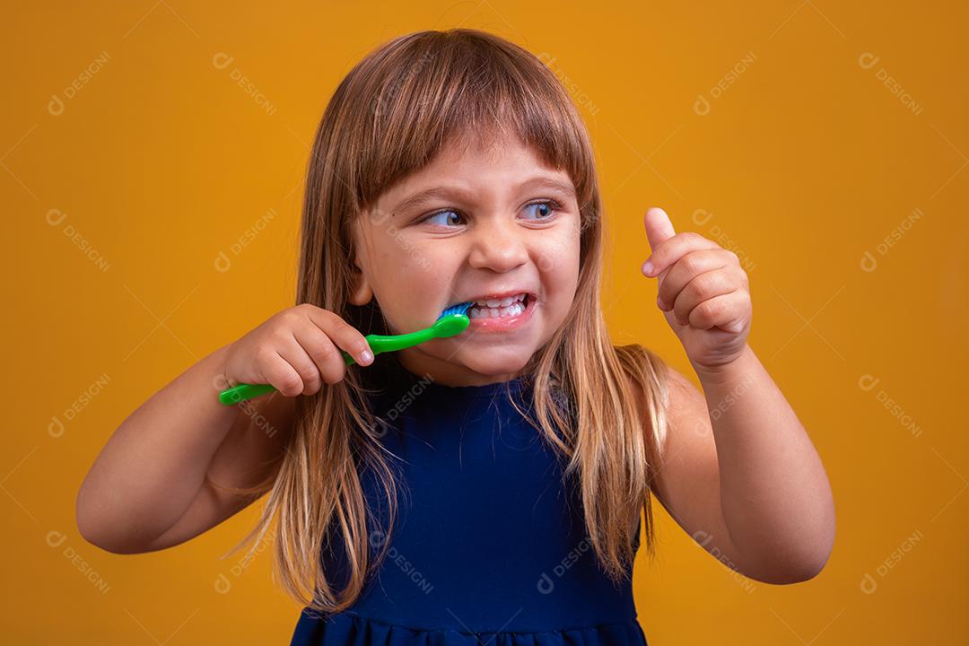 menina escovando os dentes e polegares para cima