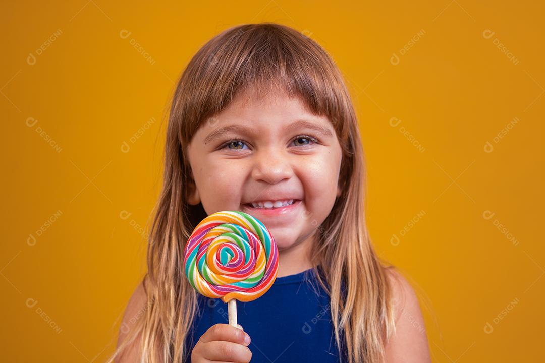 linda criança feliz com pirulito de doces, garota feliz comendo big suga