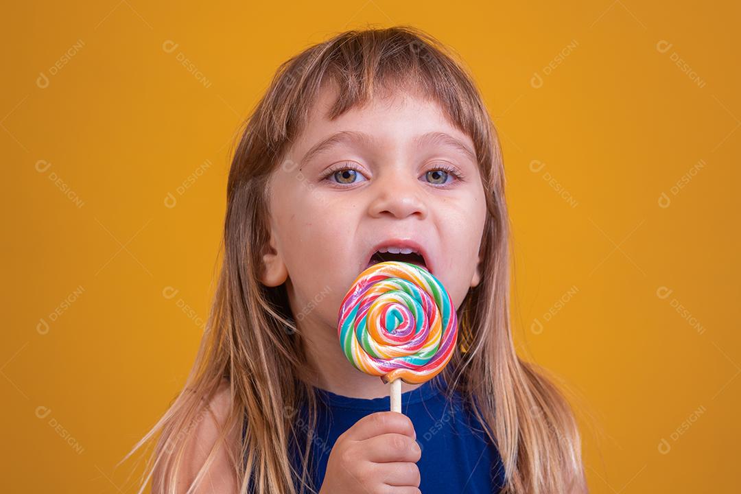 linda criança feliz com pirulito de doces, garota feliz comendo big suga