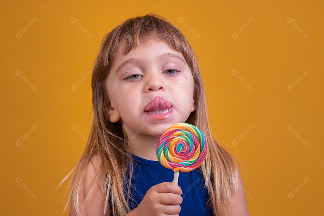linda criança feliz com pirulito de doces, garota feliz comendo big suga