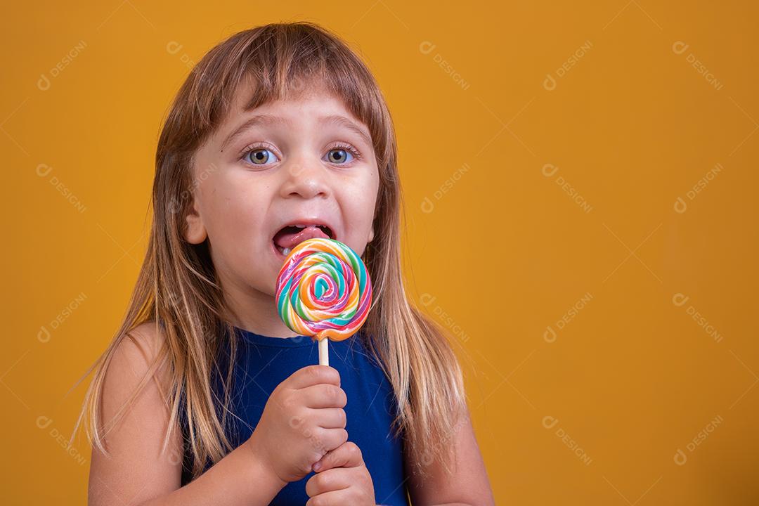 linda criança feliz com pirulito de doces, garota feliz comendo big suga