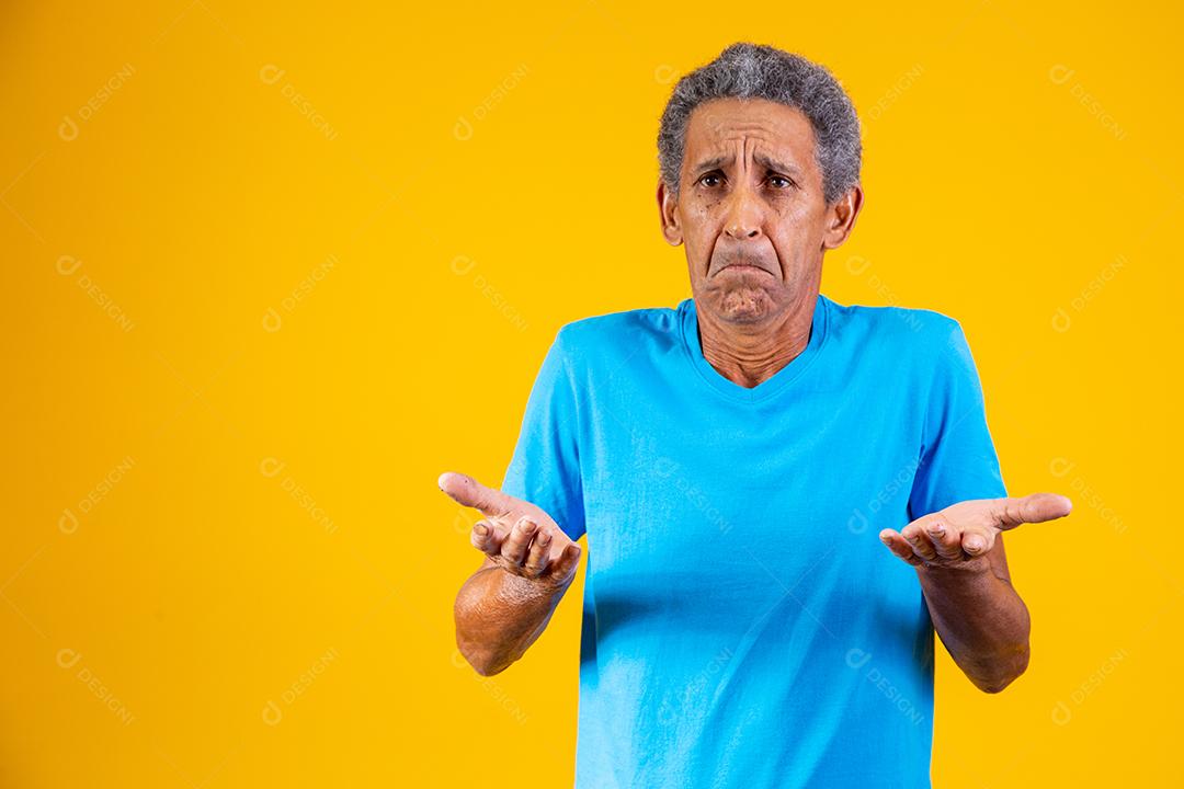 Homem idoso com expressão de duvida em fundo amarelo