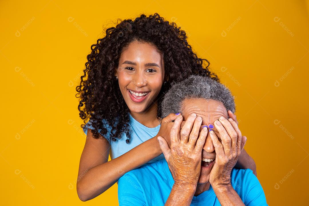 Pai e filha abraçados com camisetas azuis em fundo amarelo