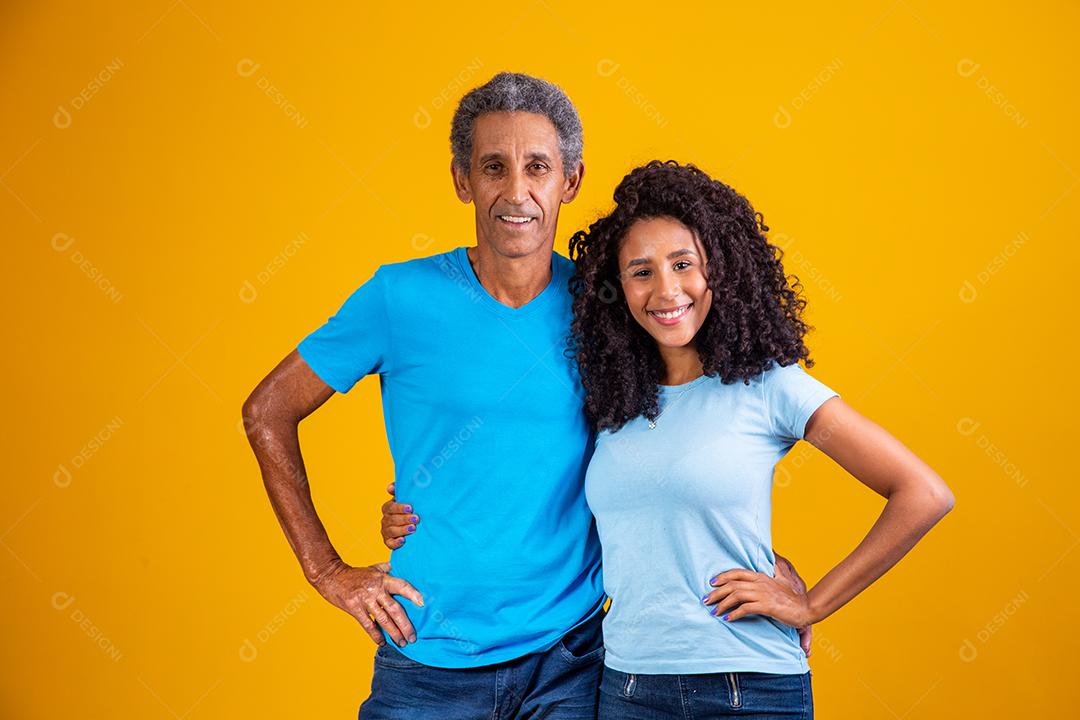 Pai e filha negros olhando para a câmera sorrindo
