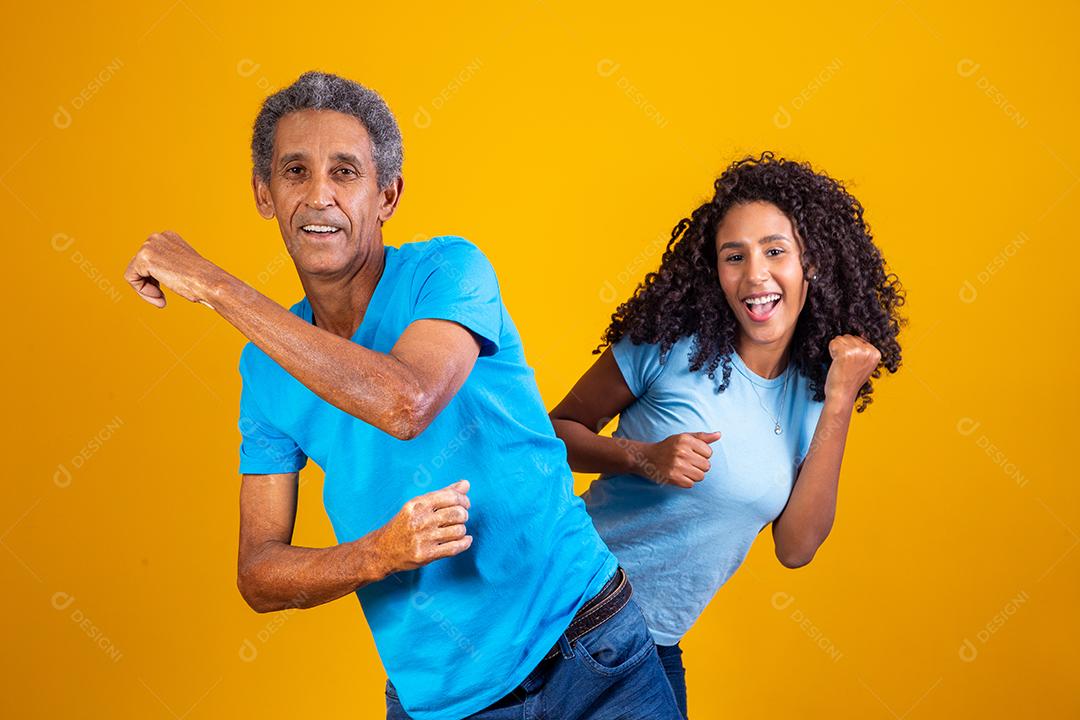 elderly afro man with his daughter dancing.