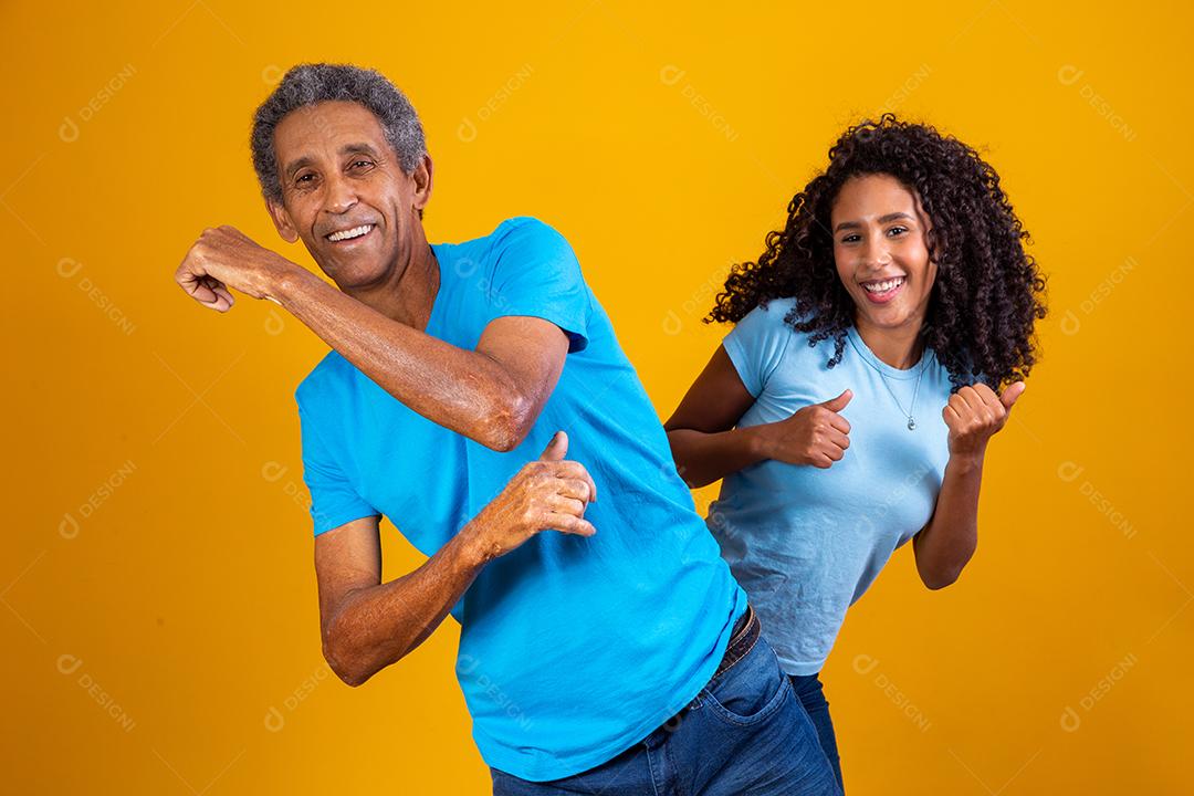 homem afro idoso com sua filha dançando.