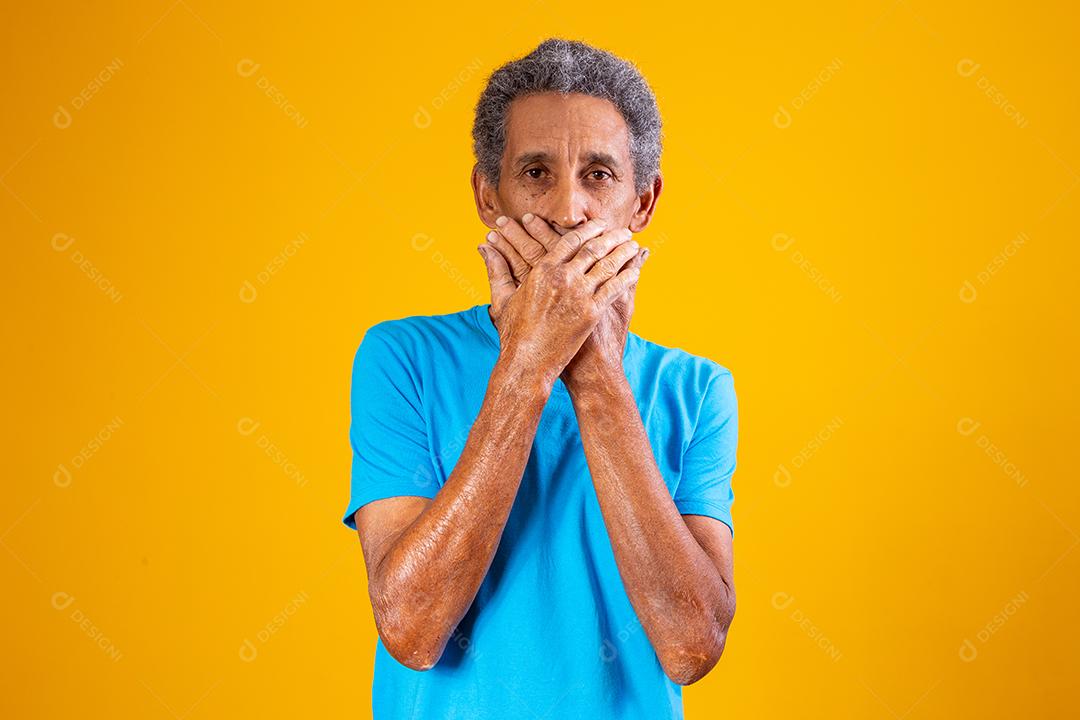 homem negro idoso com a mão sobre a boca em silêncio. conceito de racismo