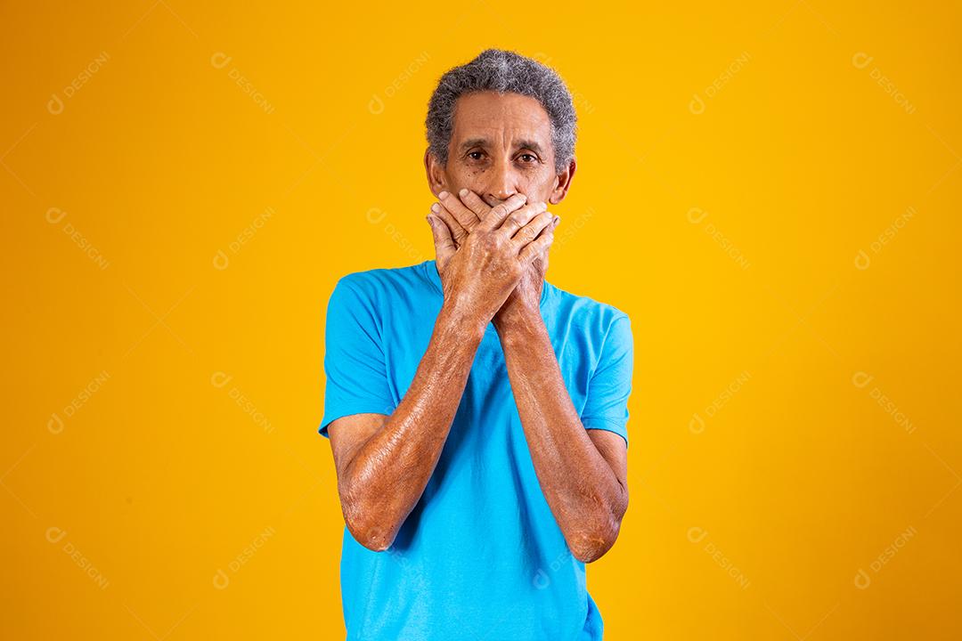 homem negro idoso com a mão sobre a boca em silêncio. conceito de racismo