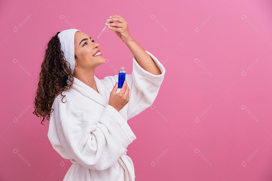 Linda jovem afro com óleo cosmético na cor de fundo