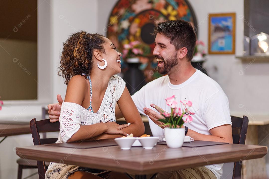 jovem casal de amantes jantando no restaurante.