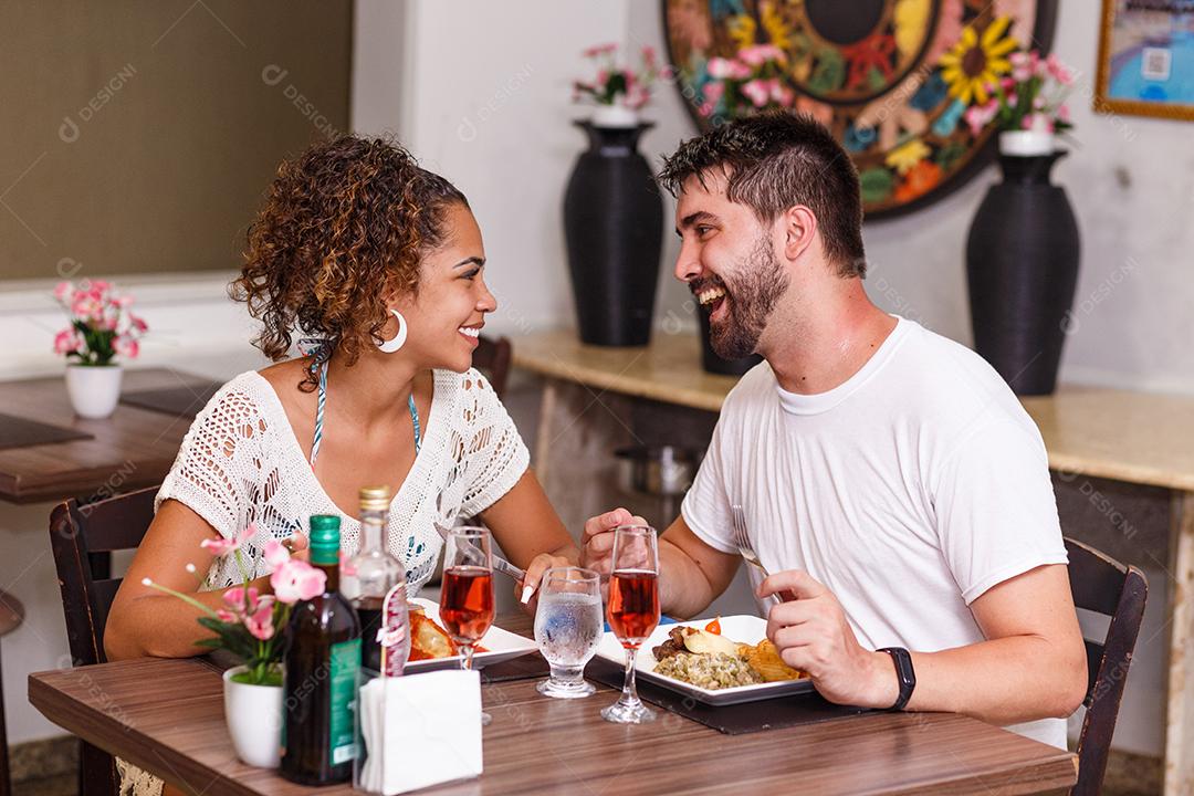jovem casal de amantes jantando no restaurante.