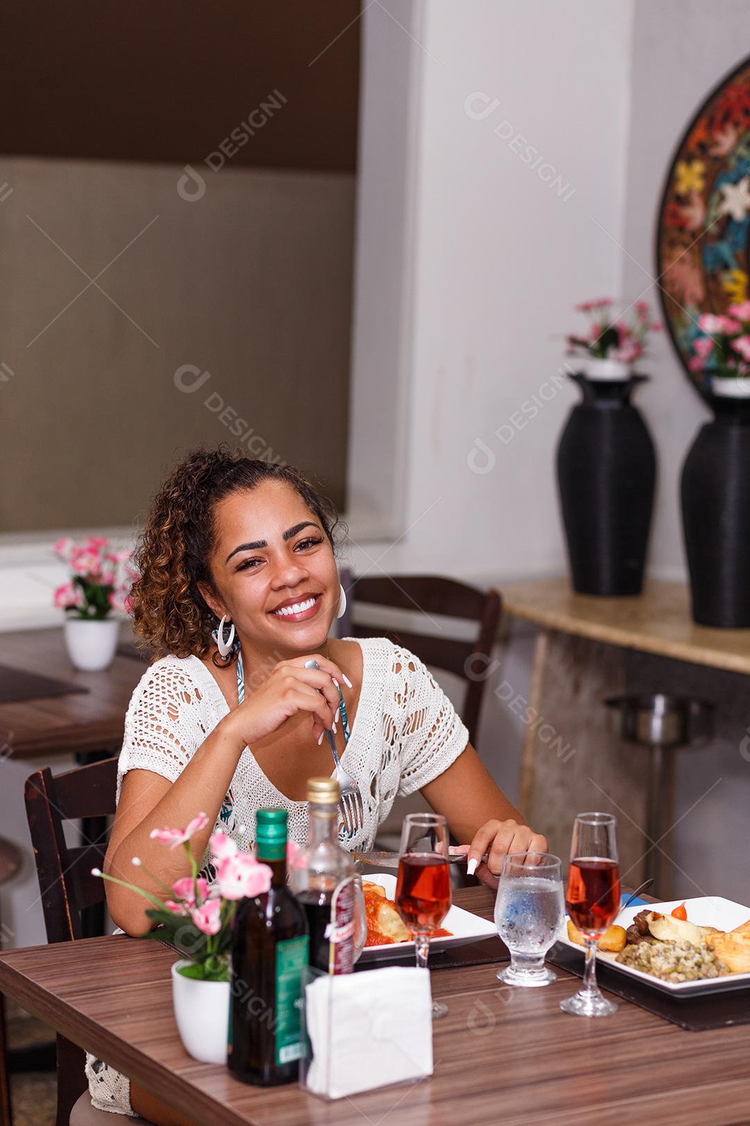 mulher comendo um delicioso prato de carne e macarrão à parmegiana.