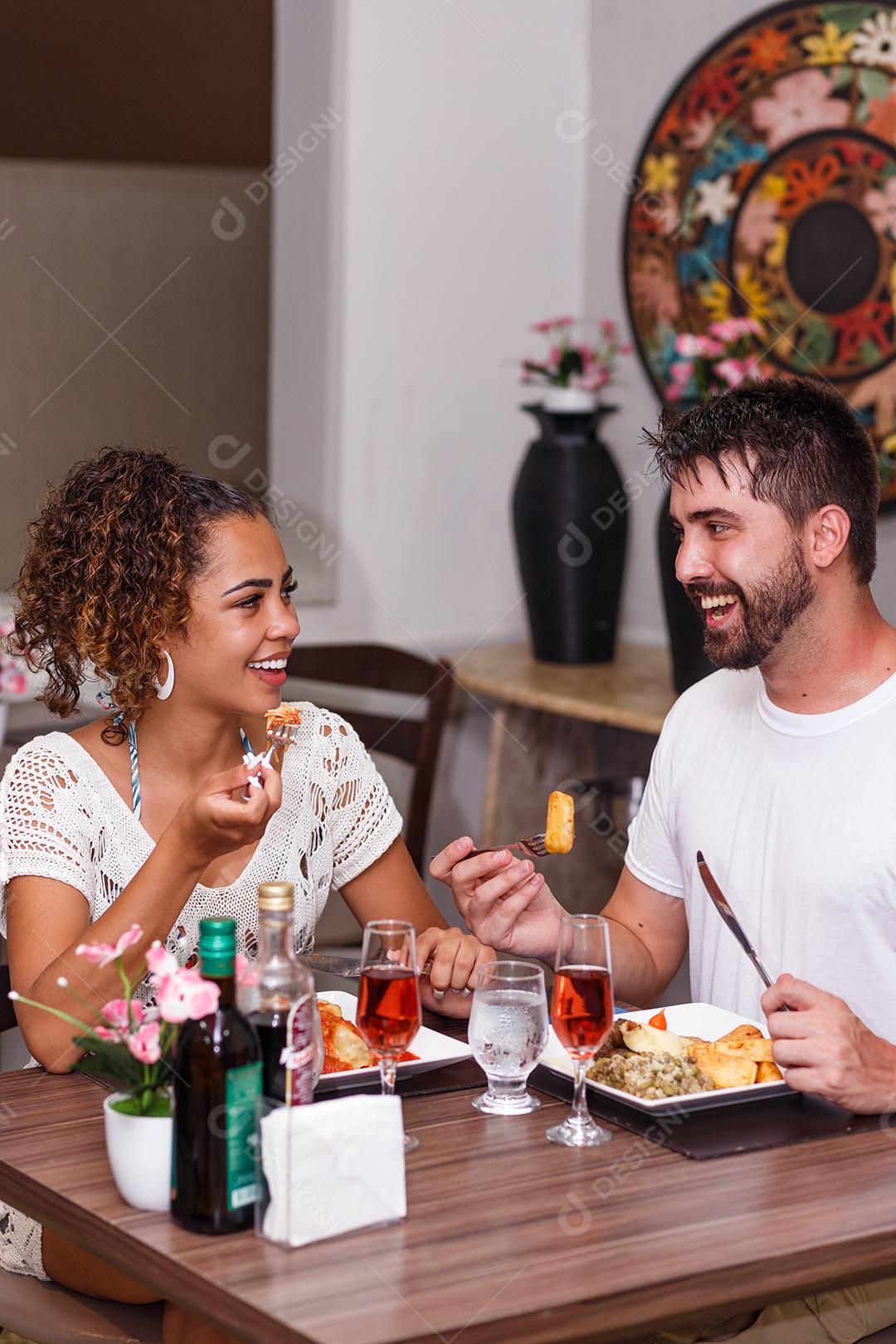 jovem casal de amantes jantando no restaurante.