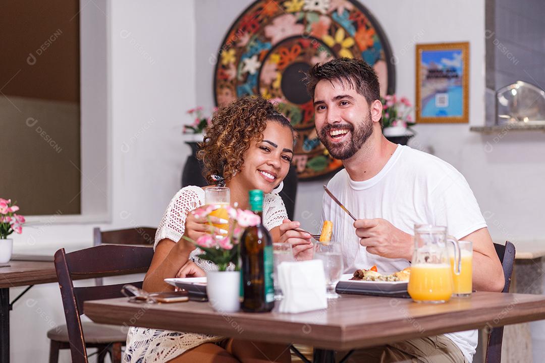 jovem casal de amantes jantando no restaurante.
