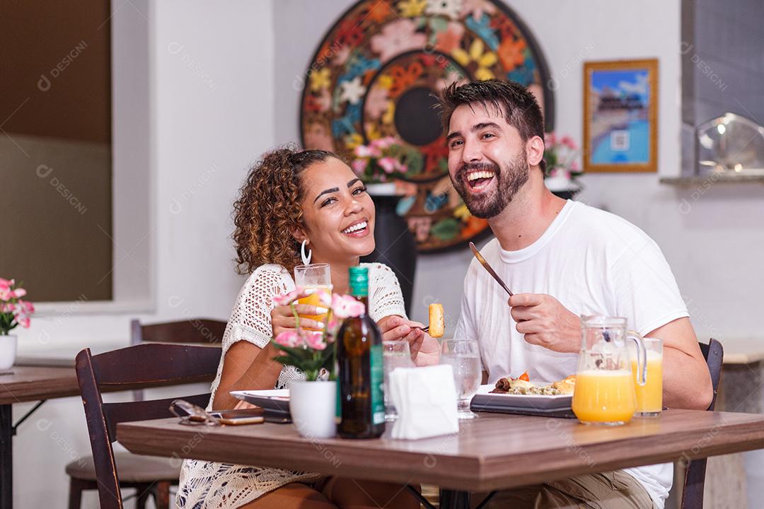 jovem casal de amantes jantando no restaurante.