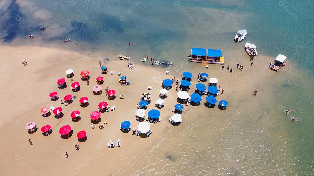foto de cadeiras e guarda-chuva com um lago ao fundo. Praia, férias e verão