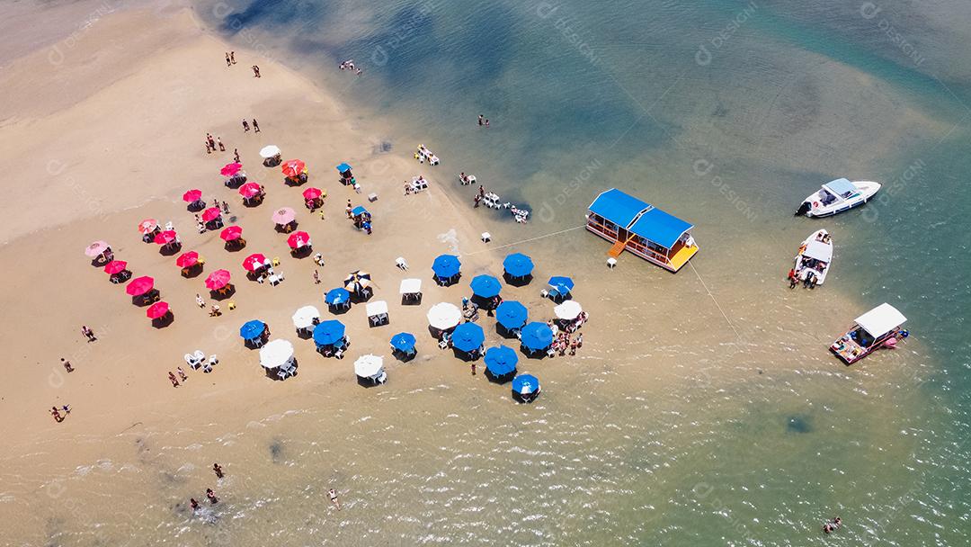 foto de cadeiras e guarda-chuva com um lago ao fundo. Praia, férias e verão