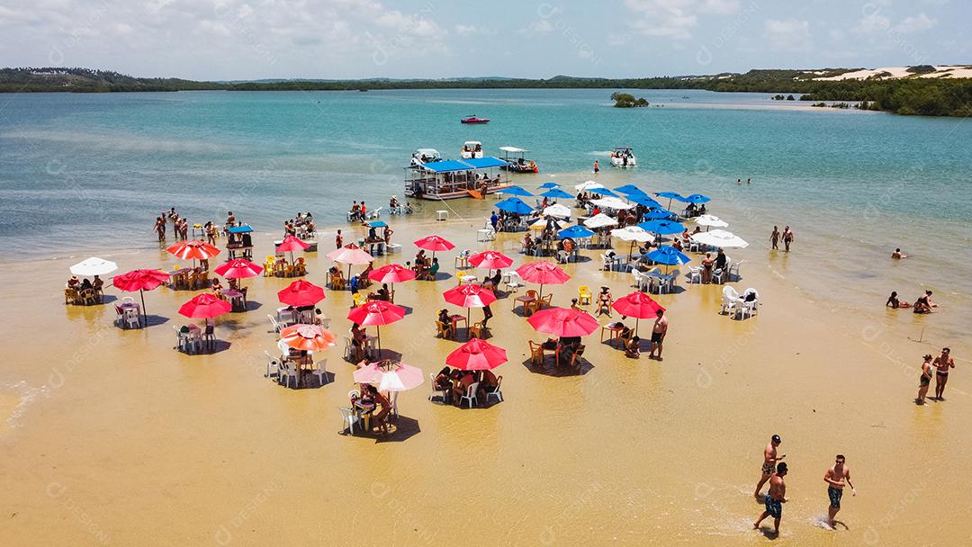 foto de cadeiras e guarda-chuva com um lago ao fundo. Praia, férias e verão