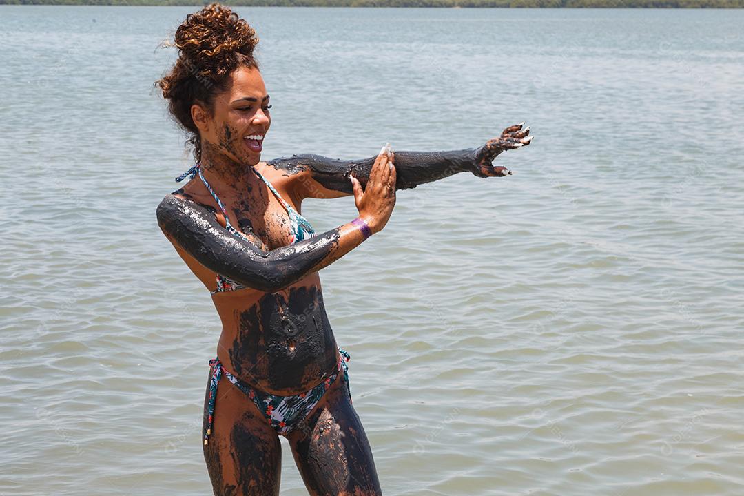 Afro young man bathing in natural clay in the river.