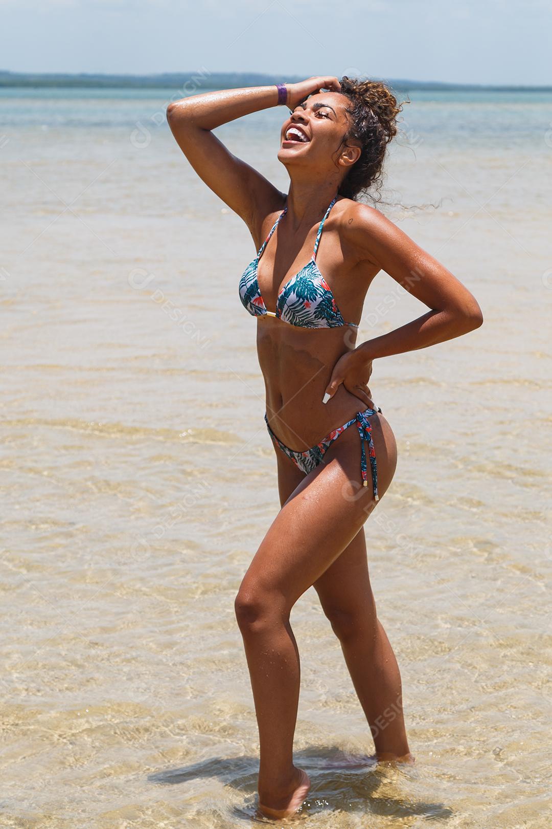 Jovem morena com biquíni colorido no verão.