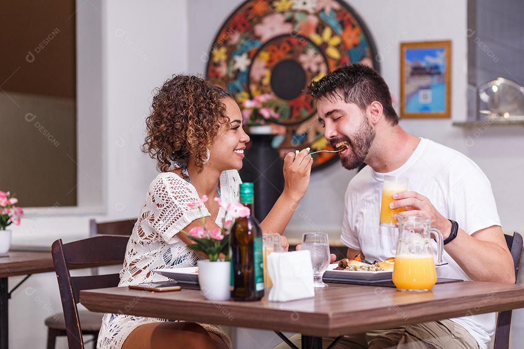 jovem casal de amantes jantando no restaurante.