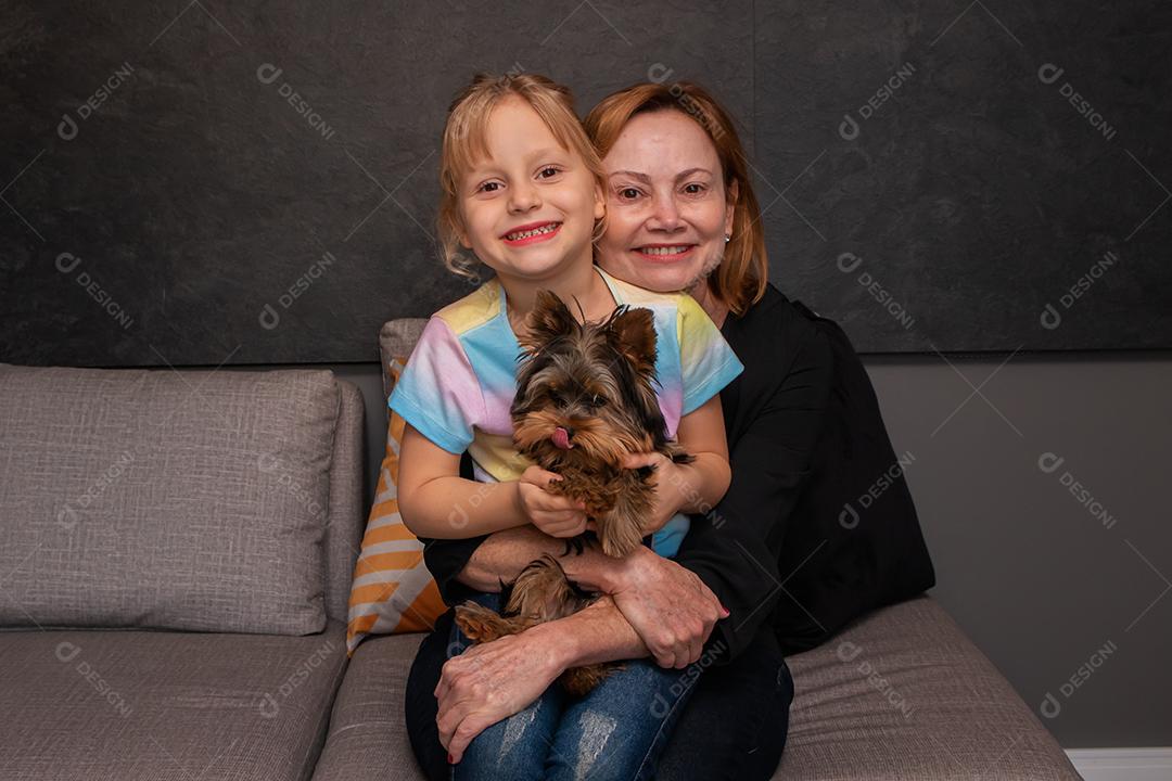 mãe e filha no sofá da sala abraçando seus