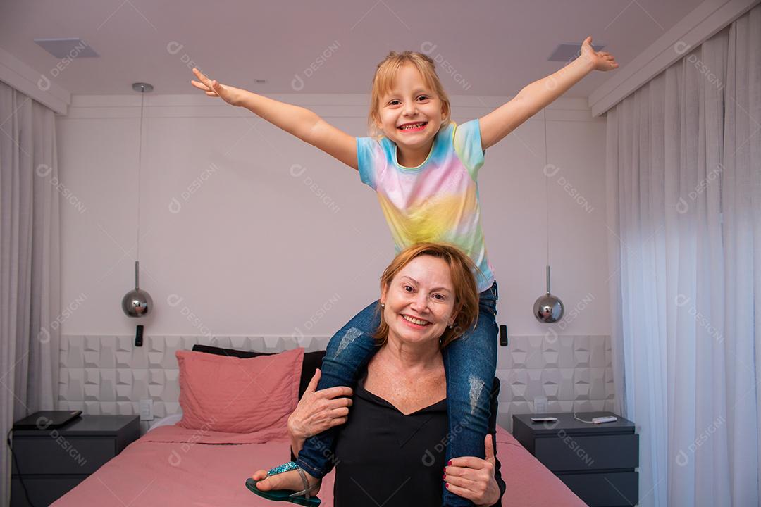 mãe madura e filha criança brincando sorrindo olhando