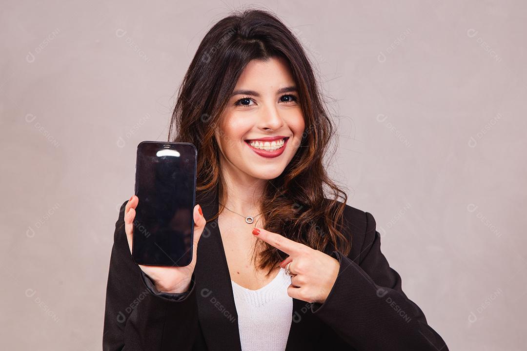 Retrato de empresária alegre mostrando o celular em s em branco