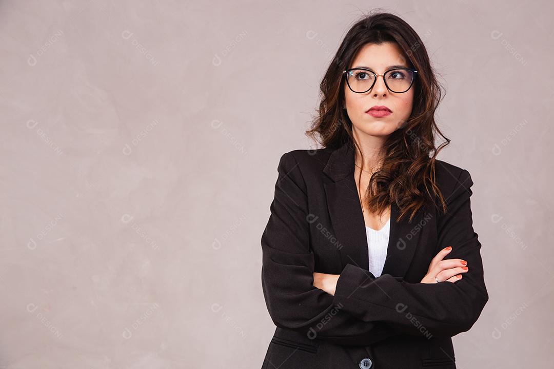 Mulher morena sorridente sem óculos posando com os braços cruzados
