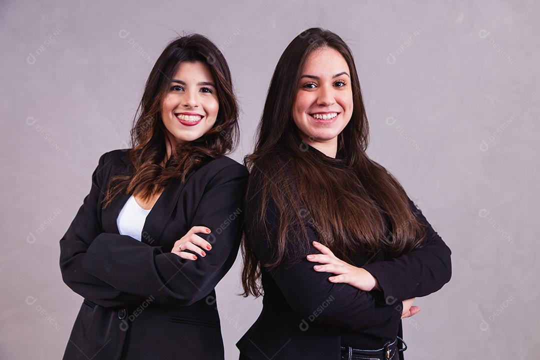 dois amigas empresárias de negócios em fundo cinza
