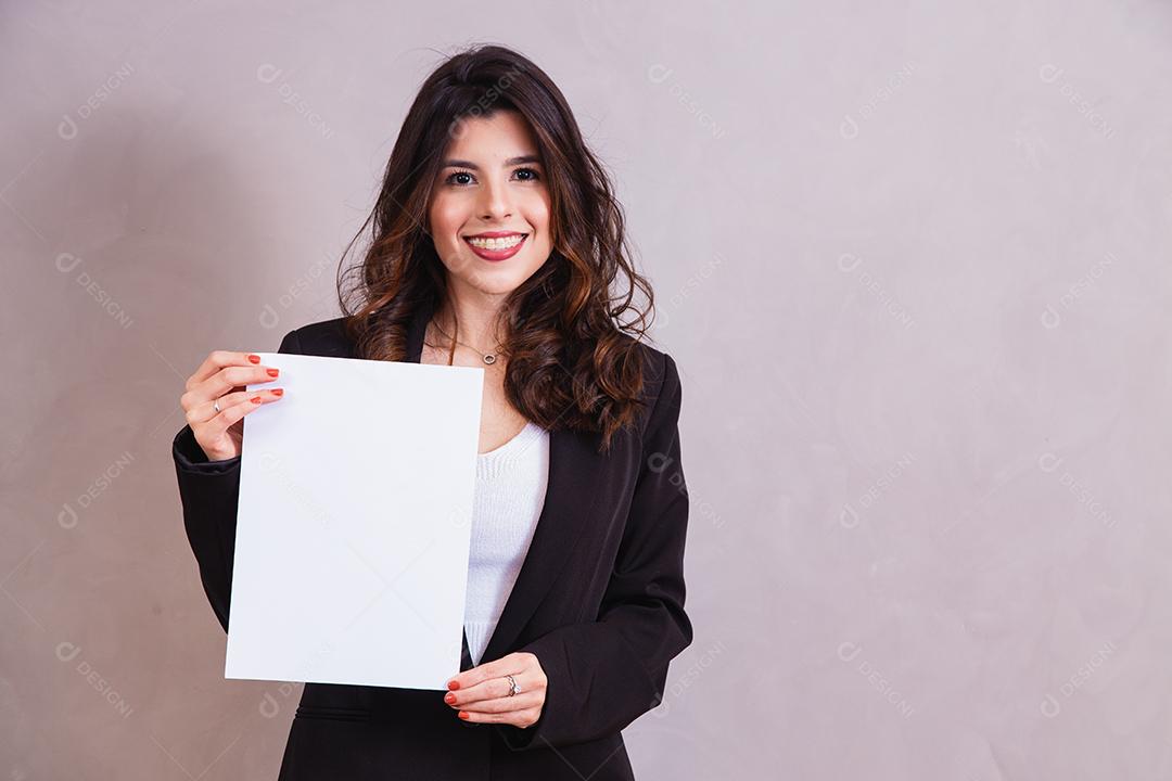 Mulher bonita de blazer preto segurando papel em fundo cinza
