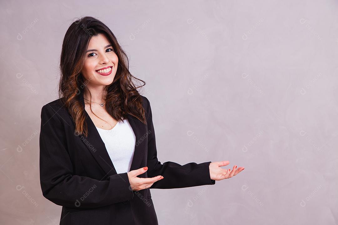 Mulher bonita de blazer preto segurando papel em fundo cinza