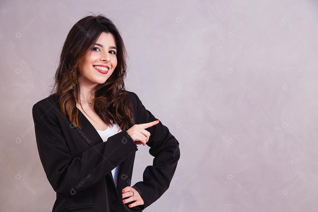 Mulher bonita de blazer preto em fundo cinza
