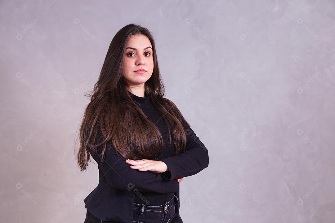 Mulher bonita de blazer preto em fundo cinza