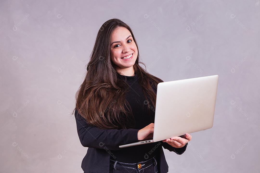 Mulher bonita de blazer preto Segurando notebook em fundo cinza