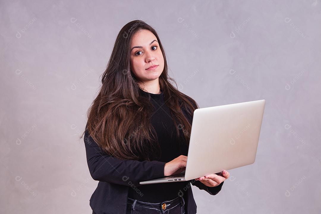 Mulher bonita de blazer preto Segurando notebook em fundo cinza