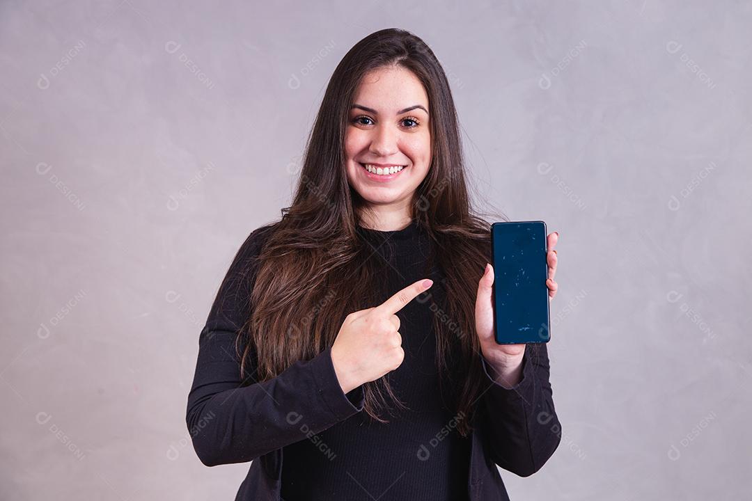 Mulher bonita de blazer preto Segurando celular em fundo cinza