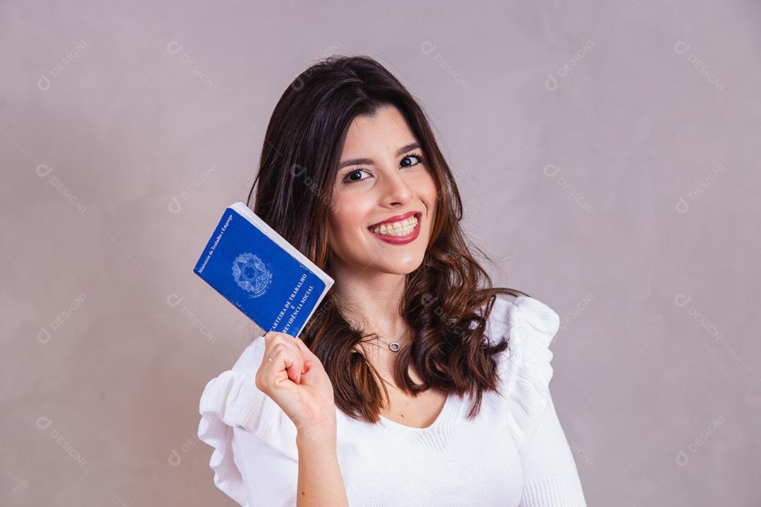 Beautiful woman in white outfit holding workbook on gray background
