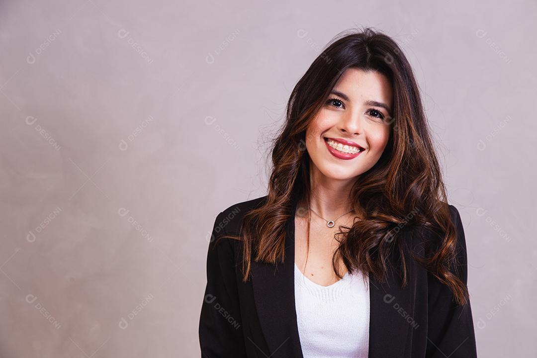 Mulher bonita de blazer preto em fundo cinza