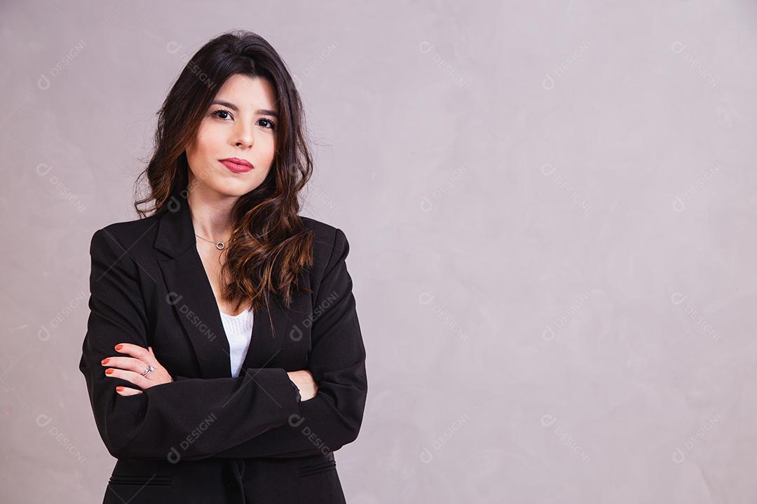 Mulher bonita de blazer preto em fundo cinza