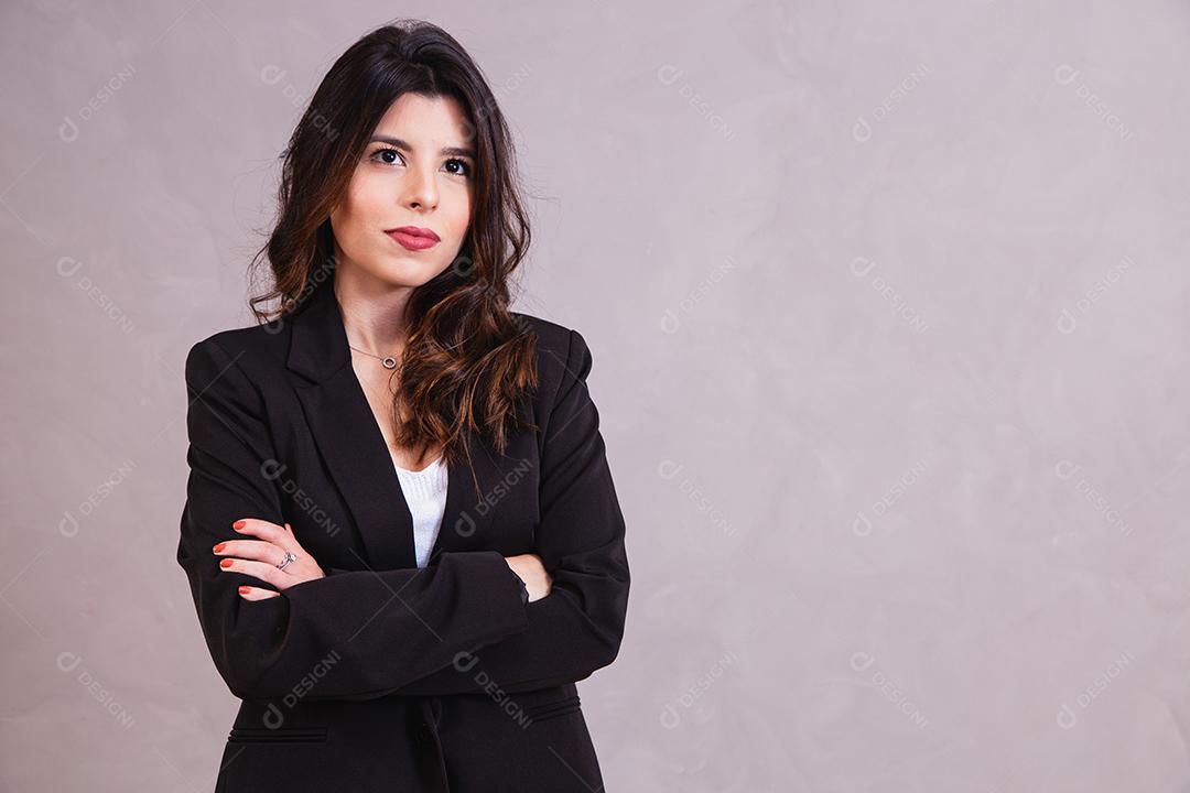 Mulher com blazer preto em fundo cinza