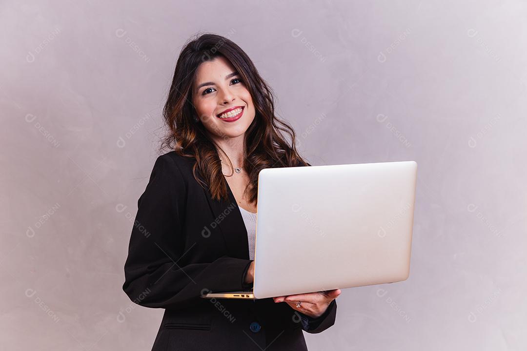 Mulher bonita segurando Notebook em fundo cinza