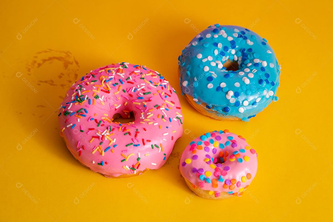 Deliciosos Donuts coloridos em fundo amarelo